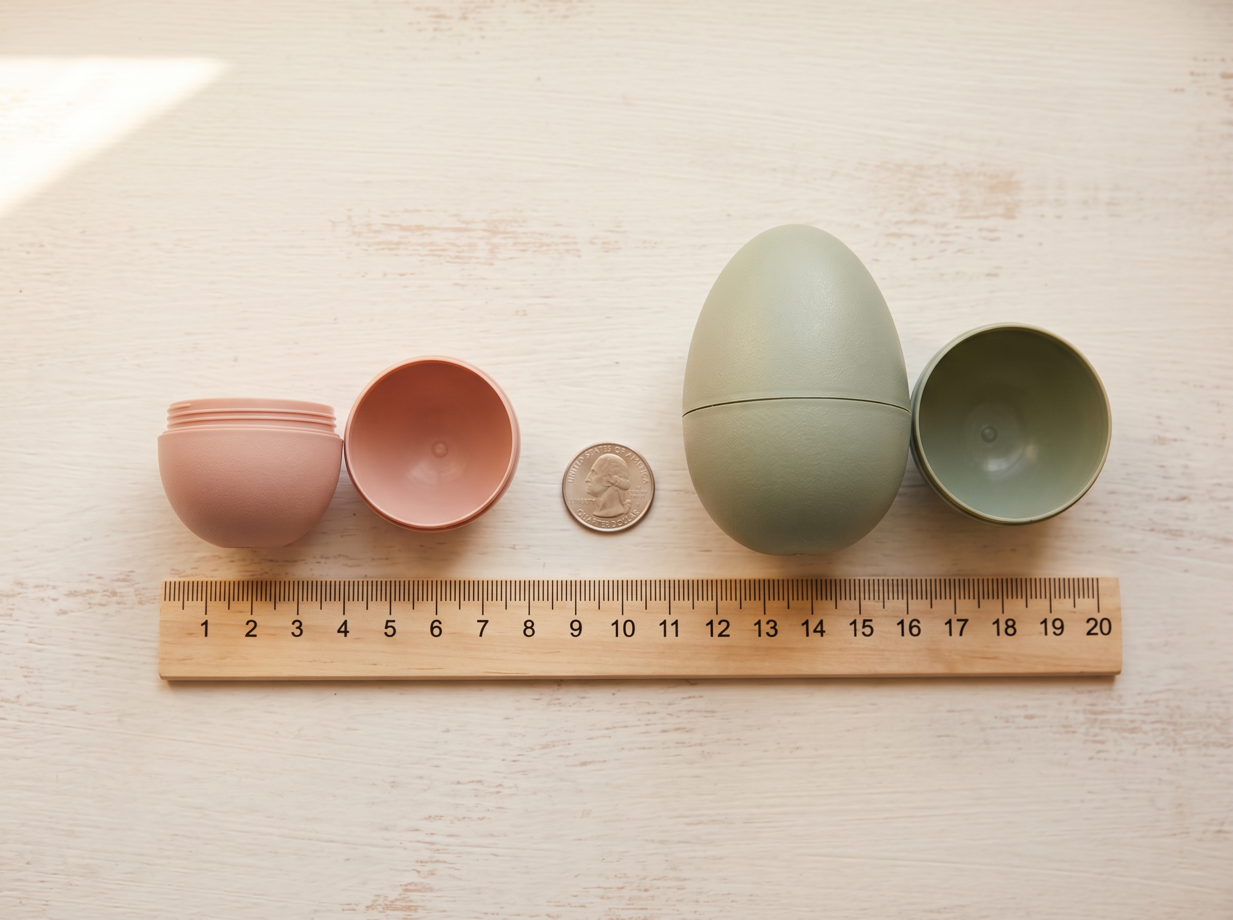 Standard and jumbo plastic Easter eggs side by side with a ruler and quarter coin showing size scale