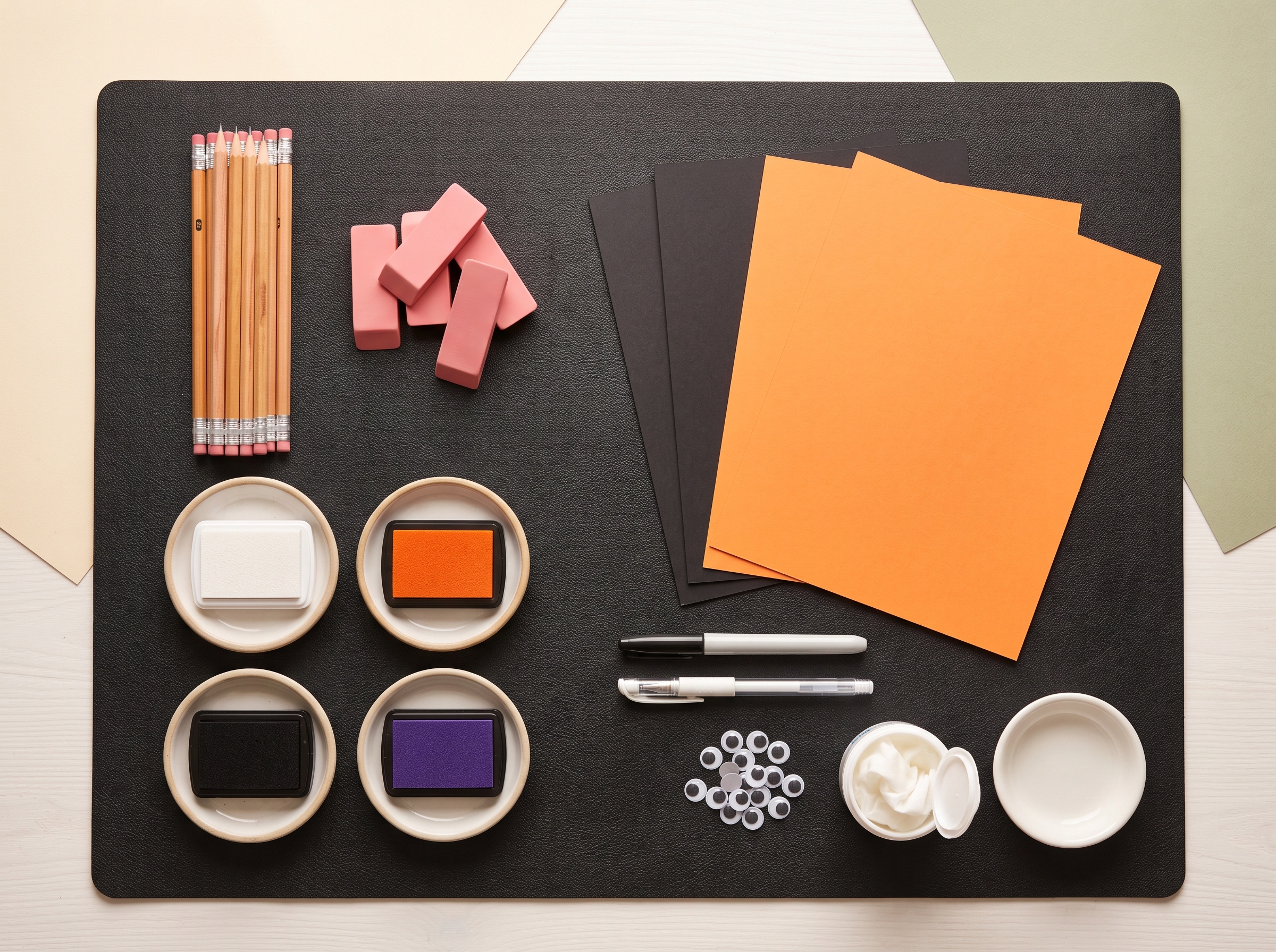 Organized craft materials for ghost eraser stamp art including pencils, block erasers, ink pads, cardstock, markers